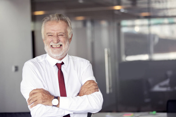 Happy handsome old businessman standing and smiling in office - Fotografie, Obrázek