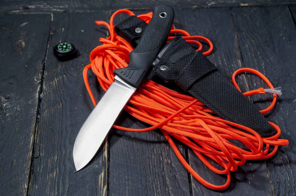 Knife of the German army. A military knife on an orange paracord cord. Black handle. - Photo, Image