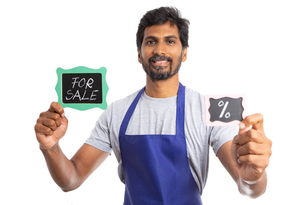 Ystävällinen intialainen myymäläpäällikkö myy yritys alennuksella kuin tilalla myytävänä ja prosenttia merkkejä molemmissa käsissä eristetty valkoinen
 - Valokuva, kuva