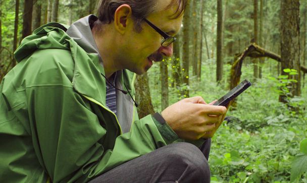 Еколог в лісі зі смартфоном
 - Фото, зображення