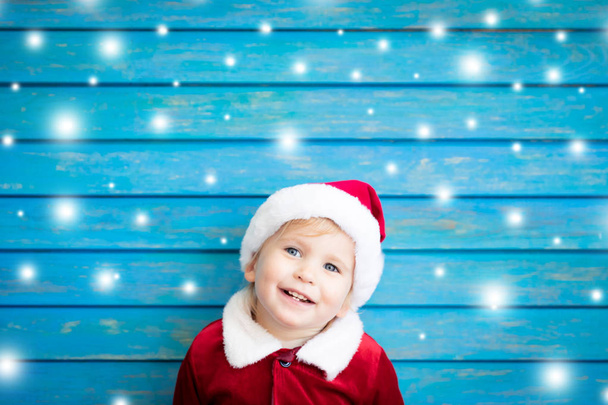 Portrait of child wearing Santa Claus costume. Kid having fun at Christmas time. Merry Xmas concept - 写真・画像