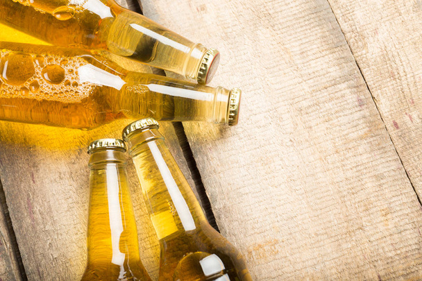 Beer bottles on a wooden table . - 写真・画像