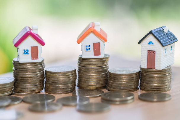 Modello di casa su pile di monete con calcolatrice come sfondo. Concetto di scala immobiliare, ipoteca e investimenti immobiliari
. - Foto, immagini
