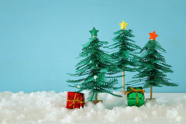 Image of paper christmas trees over white snow - Foto, immagini