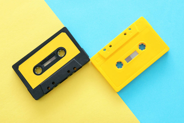 Retro cassette tape over yellow and blue double colorful background. top view. copy space - Фото, зображення