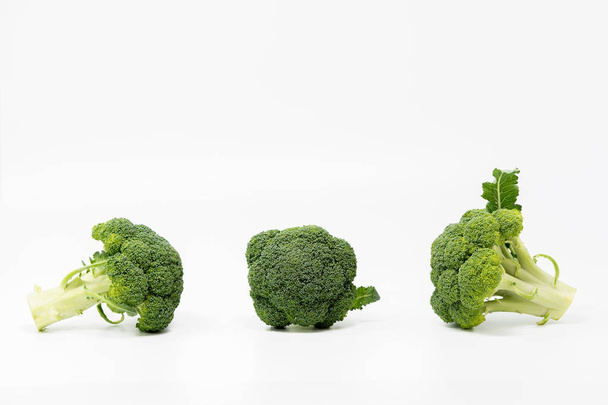Three broccoli isolated on the light background. - Foto, imagen