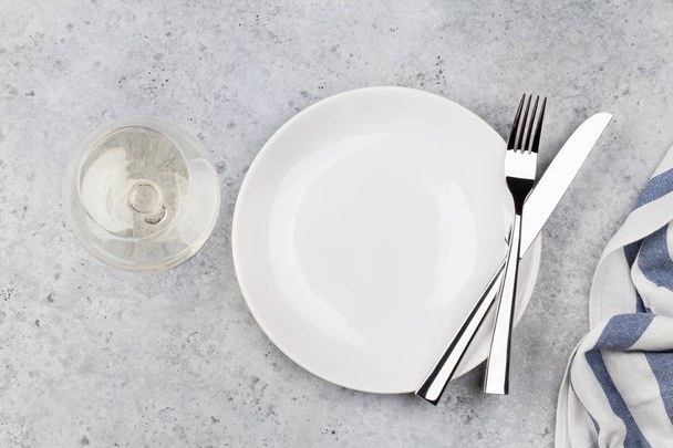 Table setting. Empty plate, knife, fork, wine glass and napkin. Top view and flat lay with copy space - Zdjęcie, obraz