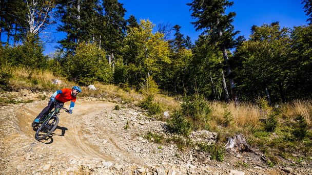 Mountain biker riding on bike in early spring mountains forest landscape. Man cycling MTB enduro flow trail track. Outdoor sport activity. - Foto, Imagen