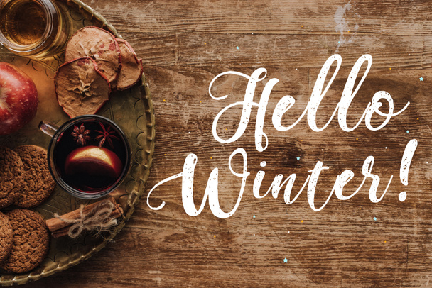 vista superior de vino caliente en copa y saludo Hola invierno en la mesa de madera, concepto de Navidad
 - Foto, imagen