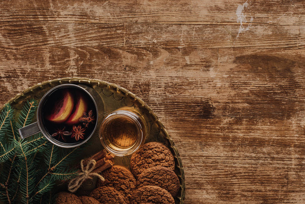 vista superior do vinho ruminado na xícara e biscoitos na mesa de madeira, conceito de natal
 - Foto, Imagem