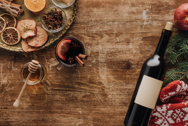 το Top view φλιτζάνι mulled κρασί και κρασί μπουκάλι ξύλινη επιτραπέζια, Χριστούγεννα έννοια - Φωτογραφία, εικόνα