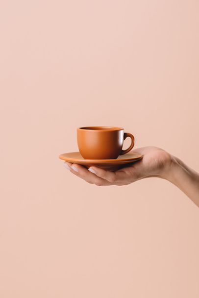 cropped shot of woman holding cup of coffee isolated on beige - Photo, Image