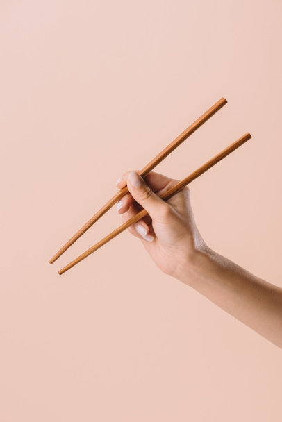 Kırpılan çekim üzerinde bej izole chopsticks tutan kadın - Fotoğraf, Görsel