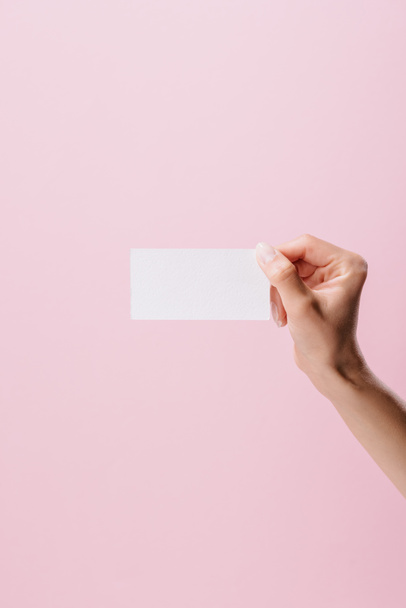 abgeschnittene Aufnahme einer Frau mit leerer Visitenkarte isoliert auf rosa - Foto, Bild