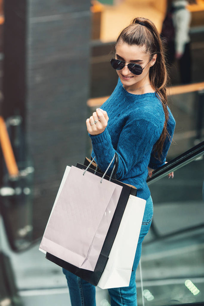 Piękna dziewczyna z torby papierowe na schodach w supermarkecie - Zdjęcie, obraz