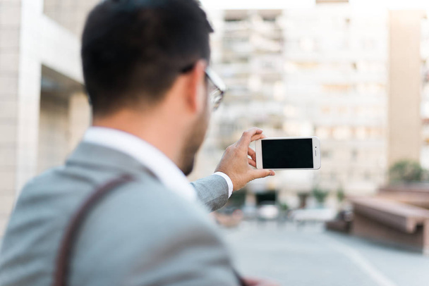 Young beautiful successful businessman taking selfie with his phone. - 写真・画像