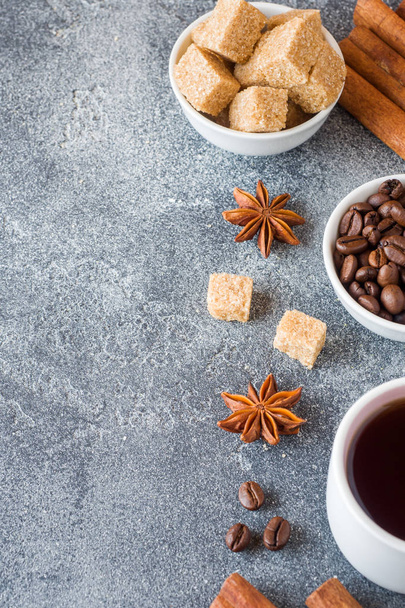 Cup of coffee, brown sugar and cinnamon with anise on concrete background. Copy space. - Zdjęcie, obraz