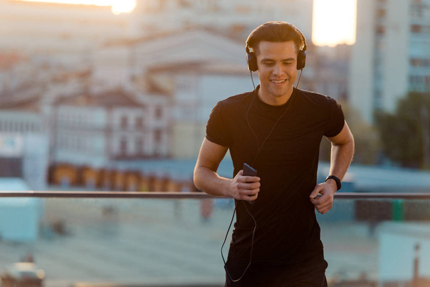 Joyful man running and listening - Фото, изображение