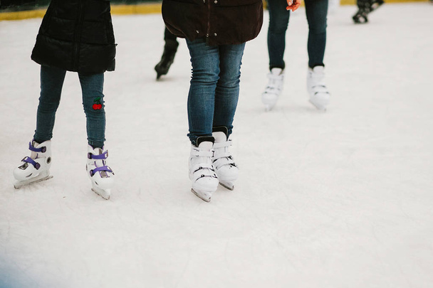 氷の上でスケート選手は冬の休日のヨーロッパの都市の中心部のリングします。ホワイトで遊ぶ子供たちはアイス スケート リング、健康的な活動です。白いスケートで子供の足 - 写真・画像