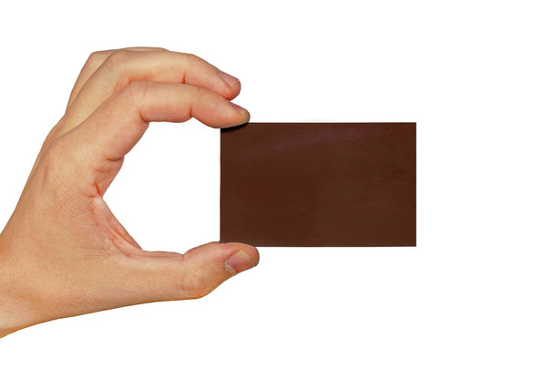 Mão segurando um cartão de visita isolado no fundo branco. Cartão de visita marrom escuro na mão masculina isolado no fundo branco
 - Foto, Imagem