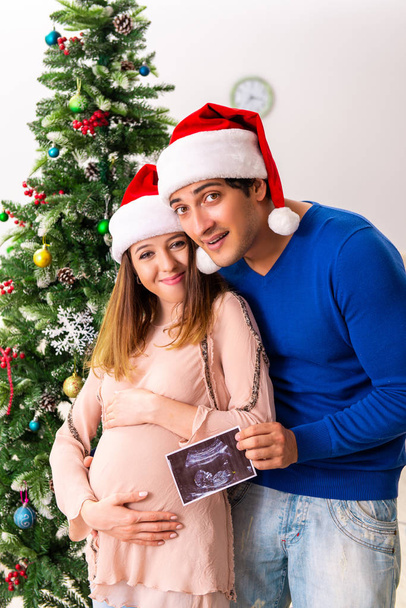 Έγκυος σύζυγος celevrating Χριστούγεννα με τον σύζυγο - Φωτογραφία, εικόνα