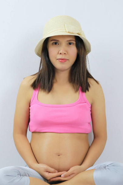 embarazada de bastante asiático mujeres uso rosa camisa están meditando para calmar en su mente
. - Foto, Imagen