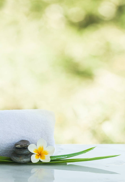 Flower and stones for massage treatment on white light background. - Photo, Image