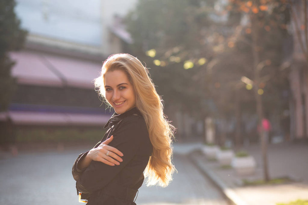 Lifestyle portrait of cheerful blonde woman with lush curly hair posing with sun glare. Empty space - Фото, зображення