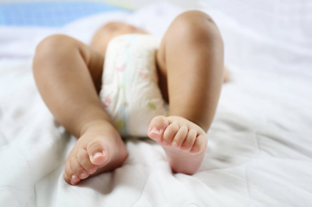 Baby 's Foot of Asian Infant на кровати в понятии здоровья и роста
. - Фото, изображение