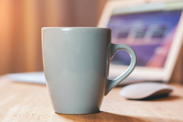 Grey mug on the wooden table. Office workspace background - Foto, Imagen
