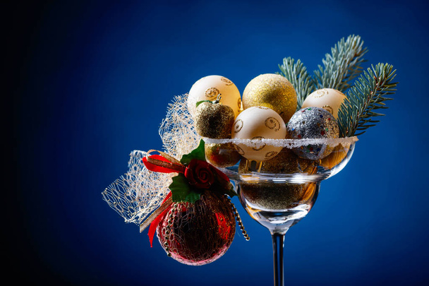 Christmas balls in wineglass on a dark blue background. Copy space . - Фото, зображення