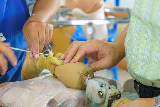 Técnico médico fazer uma nova prótese de alumínio pernas para paciente amputado
. - Foto, Imagem
