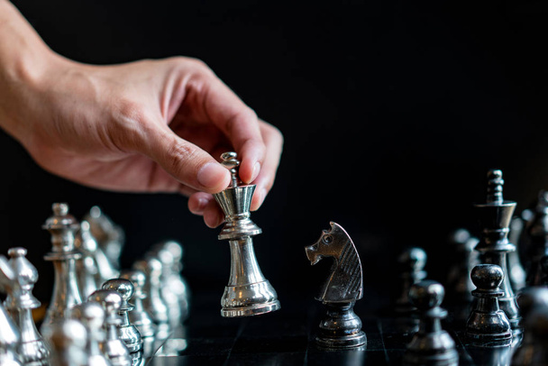 рука бизнесмена движущегося шахматной доски в игре успеха соревнования. - Фото, изображение