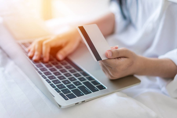 Bir laptop ve kullandığı kredi kartı üzerinde iş çalışma ve konsept alışveriş genç kadın. - Fotoğraf, Görsel