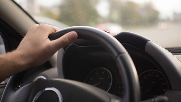 Male hand on steering wheel inside car - Fotografie, Obrázek
