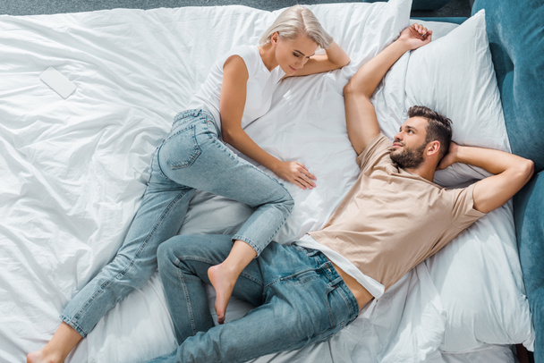 top view of happy young couple relaxing together in bedroom - Photo, Image