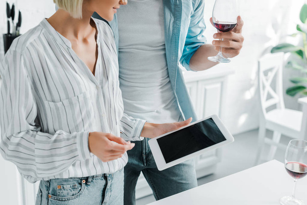 cropped image of couple using tablet with blank screen in kitchen - Zdjęcie, obraz