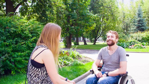 Молодий чоловік з дружиною сидить у парку
 - Фото, зображення