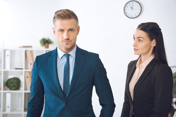 portrait of businesswoman looking at confident colleague in office - Foto, afbeelding