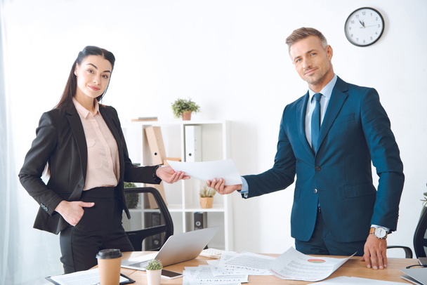 businesswoman giving document to colleague at workplace in office - Foto, Imagem