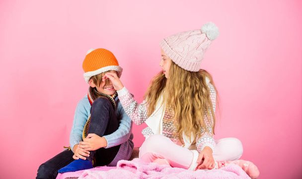 Children playful mood christmas holidays pink background. Winter accessories for kids. Girl and boy wear knitted winter hats. Winter season fashion accessories and clothes. Kids knitted winter hats - Valokuva, kuva