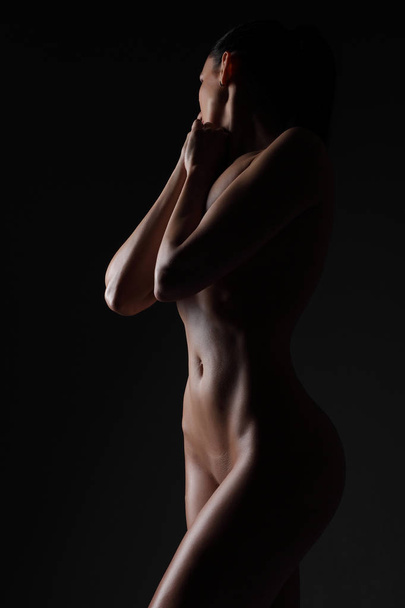 joven deporte chica desnuda sobre un fondo oscuro
 - Foto, Imagen