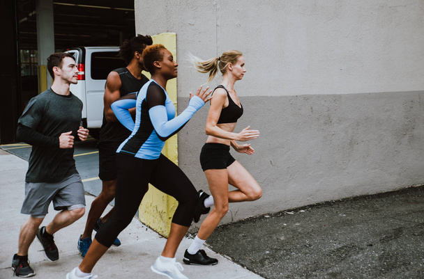 Group of urban runners running on the street in New york city, conceptual series about sport and fitness - Foto, Bild