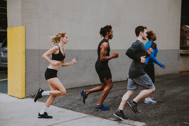 Group of urban runners running on the street in New york city, conceptual series about sport and fitness - Фото, зображення