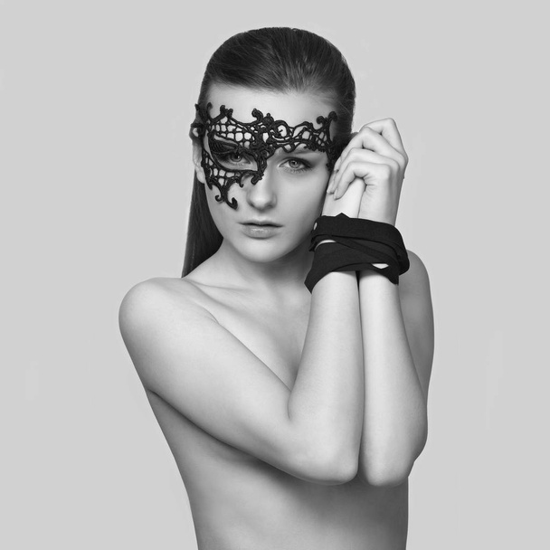 портрет молодой сексуальной женщины в маске и со связанными руками
 - Фото, изображение