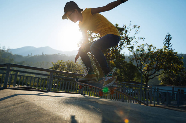 Skateboarder doing ollie at skatepark at summer - Foto, Bild