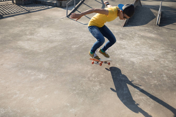 Skateboarder doing ollie at skatepark at summer - Фото, изображение