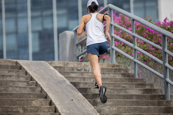 Young woman runner sportswoman running upstairs - Foto, immagini