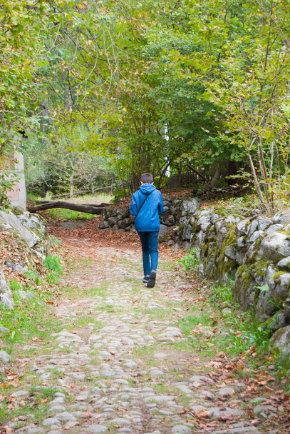 Adolescente caminando en una pendiente rocosa empinada en las montañas
 - Foto, Imagen