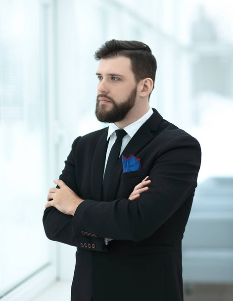 confident businessman standing near the office window - Фото, изображение